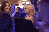 a blurry picture of a group of people including a woman in a blue dress