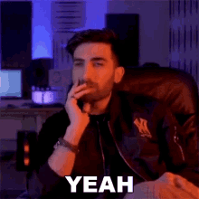 a man is smoking a cigarette while sitting in a chair and says yeah .