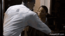 a man in a white shirt is standing next to a woman in a room .