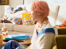 a person sitting on a couch with a bag of popcorn behind them
