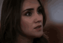 a close up of a woman 's face with a slight smirk on her face .