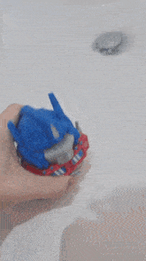 a person is holding a toy in their hand in front of a bathtub