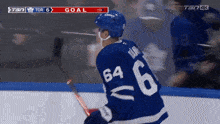 a hockey player with the number 64 on his jersey stands on the ice