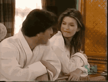 a man and a woman are sitting next to each other and the woman is smiling