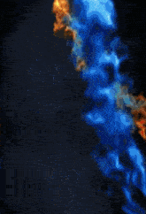 a yellow and blue fire is coming out of a black background .