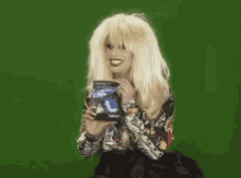 a woman with blonde hair is holding a can of soda