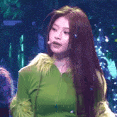 a woman with long hair is wearing a green jacket with fur sleeves