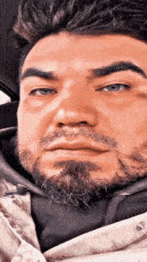 a man with a beard is wearing a white jacket