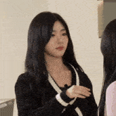a girl wearing a black sweater with white stripes on the sleeves