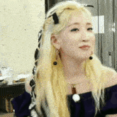 a woman with blonde hair is wearing a black top and earrings
