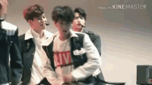 a group of young men are standing next to each other on a stage and one of them is dancing .