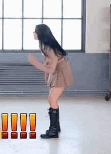 a woman in a brown skirt and black boots is dancing in a room .