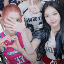 a girl wearing a cowboys jersey stands next to another girl