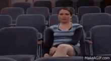 a man and a woman are sitting in a movie theater talking to each other .