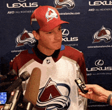 a hockey player is being interviewed in front of a lexus ad