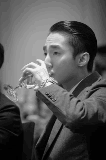 a man in a suit drinks from a glass