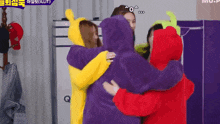 a group of girls are hugging each other in purple and yellow hoodies