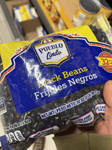 a person is holding a bag of black beans