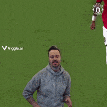 a man stands on a soccer field with a manchester united logo on his jersey