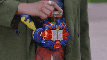 a person is holding a toy that looks like a robot with a sword .