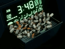 a bunch of cigarettes are laying on a tray with a clock that says 3:48 am
