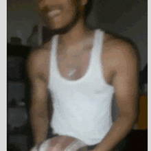 a man wearing a white tank top is smiling and holding a basketball .