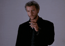 a man in a suit and tie is holding a microphone and says " this is my design "