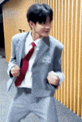 a man in a suit with a red tie is dancing