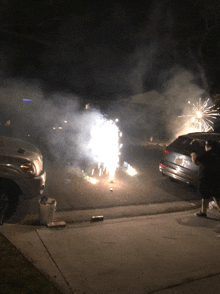a fireworks display in a driveway with a car with a license plate that starts with the letter a