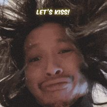 a man with his hair blowing in the wind has the words let 's kiss above his head