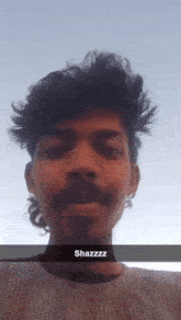 a man with a mustache is taking a selfie with a caption that says shazzzz