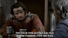 a man in a knight 's costume is talking to another man in a foreign language