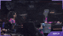 a group of people playing a video game with a purple overlay that says replay on it