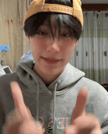 a person wearing a yellow hat and a hoodie that says ' he ' on the front