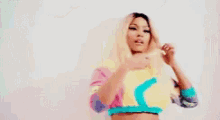 a woman in a crop top is holding a piece of paper in front of her face .