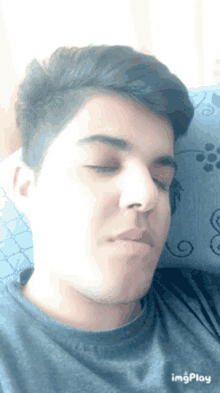a young man laying on a bed with his eyes closed and a gif of his face being displayed