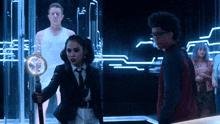 a group of people are standing in a dark room with a man in a white tank top behind them .