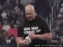 a man in a black shirt is being punched in the face by a woman in a crowd .