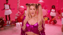 a woman with pigtails is wearing a purple top and a pearl necklace