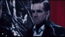 a man in a black jacket stands in a dark forest