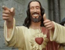 a statue of jesus is giving a thumbs up sign