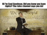 a man in a suit and tie is sitting at a desk in front of the united states constitution