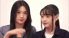 two young girls are looking at each other and one is pointing