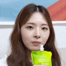 a woman is holding a green bag that says essential c-b borjac jelly on it