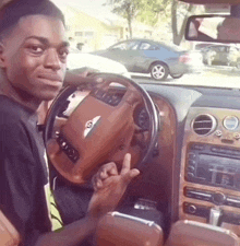 a man sitting in a car with a steering wheel that has the letter s on it