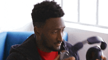 a man is sitting in a chair holding a pair of headphones in his hand .