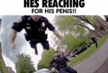 two police officers are reaching for a man 's penis on a street