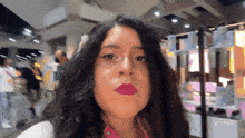 a woman with long dark hair wearing pink lipstick