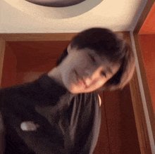 a woman in a black shirt is smiling and looking up