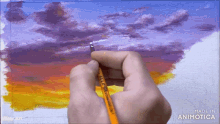 a person is painting a sunset with a brush that says made in animatica